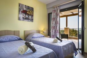 a bedroom with two beds with stuffed animals on them at Villa Karavias by Villa Select in Trapezaki +17 photos