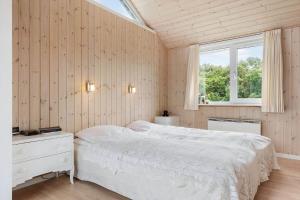 a bedroom with a white bed and a window at 1132-Ringkobing-Hvidbjergvej-32 in Søndervig