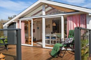 a screened in porch with a deck with a chair at 1132-Ringkobing-Hvidbjergvej-32 in Søndervig