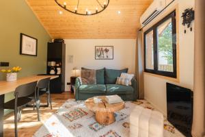 a living room with a couch and a table at Le Chalet Madrier - Terrasse et Jacuzzi privé in Tours-en-Savoie