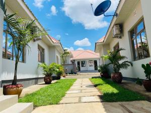 a house with a pathway in front of it at Chama Haven Appartment 2 bed in Tengeru