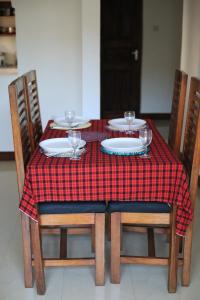 a table with a red and white checkered table cloth at Chama Haven Appartment 2 bed in Tengeru