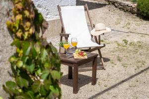 a chair with a plate of food and two glasses of wine at Carcavelos Manor House by Portugal Active in Vila Verde