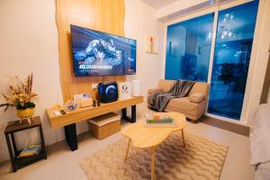 a living room with a couch and a flat screen tv at G-Luxe Panabo Guesthouse - Unit B in Panabo