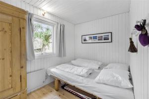 a bed in a room with a window at 1176-N-Hundested-Brune-Bakke-1 in Hundested
