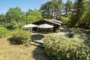a house with two umbrellas on a wooden deck at 1176-N-Hundested-Brune-Bakke-1 in Hundested