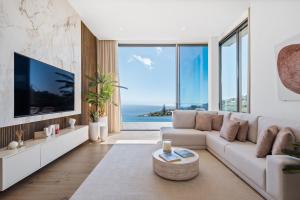 a living room with a couch and a large tv at Villa Platinum by Homie in Estreito da Calheta