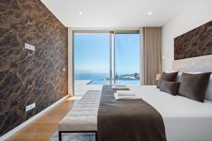a bedroom with a large bed and a large window at Villa Platinum by Homie in Estreito da Calheta +92 photos