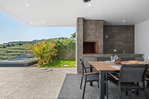 an open kitchen and dining room with a table and chairs at Villa Platinum by Homie in Estreito da Calheta