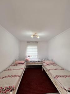 a bedroom with two beds and a window at Guesthouse'Hadicha' in Tong