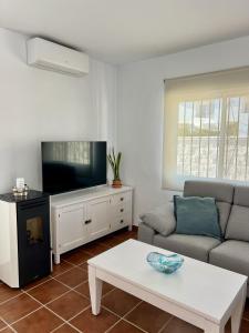 a living room with a couch and a tv at Casa caminito 2 in Zahora