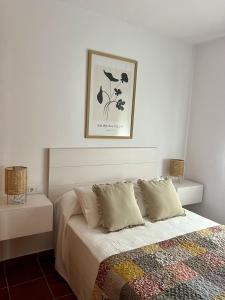 a bedroom with a bed and a picture on the wall at Casa caminito 2 in Zahora +6 photos