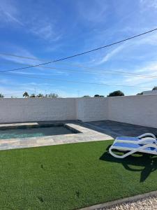 a lawn chair sitting on the grass next to a pool at Casa caminito 2 in Zahora