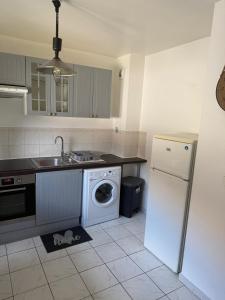 a kitchen with a sink and a washing machine at appartement cosy tout équipe in Épinay-sur-Orge +4 photos