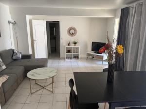 a living room with a couch and a table at appartement cosy tout équipe in Épinay-sur-Orge