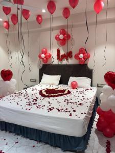 a bedroom with a bed covered in red balloons at Hotel Nee Residency in Rajkot +1 photo