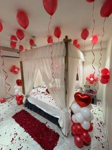 a bedroom with red and white balloons hanging from the ceiling at Hotel Nee Residency in Rajkot