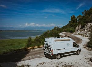a white van parked on a road next to the water at Campervan Montenegro RV in Bar +15 photos