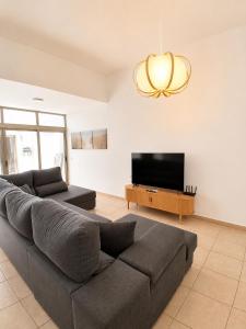 a living room with a couch and a flat screen tv at Aurea 1 Luxury House in Antigua