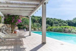 a patio with a swimming pool and a pergola at Appartamenti Le Solane - Goelba in Marmi