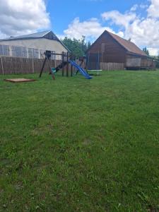 a playground with a slide in a grass field at J&L GRADZKIE in Grądzkie