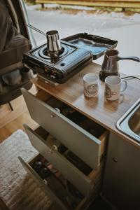 a table with a stove and two cups on it at Campervan Montenegro RV in Bar