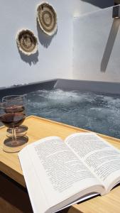 an open book on a table with a glass of wine at Anna's Village House in Perivólia