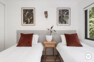 two beds sitting next to each other in a room at Peggy - Little Cove in Noosa Heads