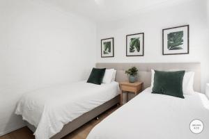 two beds sitting next to each other in a bedroom at Peggy - Little Cove in Noosa Heads +2 photos