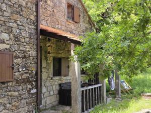 an old stone building with a porch and a tree at Casa das Candeias in Melgaço