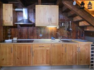 a kitchen with wooden cabinets and a sink at Casa das Candeias in Melgaço +33 photos
