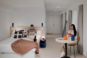 a man and woman sitting on a couch in a living room at Suiters Málaga in Málaga +11 photos