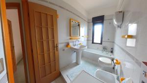 a white bathroom with a sink and a toilet at La quiete dell'Ammiraglio 1 in Ioppolo