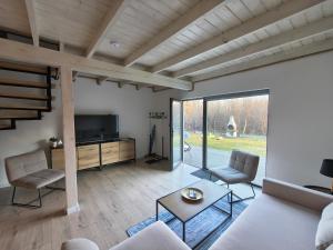 a living room with a couch and chairs and a tv at Baltic Breeze & Spa in Władysławowo