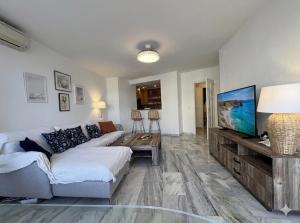 a living room with a couch and a flat screen tv at Sunset Torrox Costa in Torrox