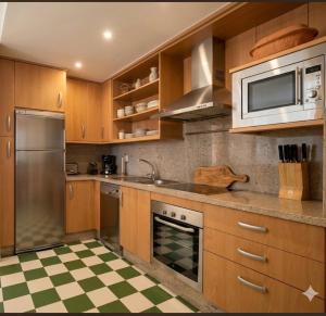 a kitchen with wooden cabinets and stainless steel appliances at Sunset Torrox Costa in Torrox