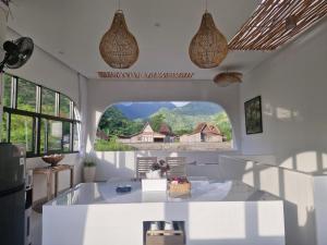 a kitchen with a large window in a white room at Bnaya Villas Riverside in Amed