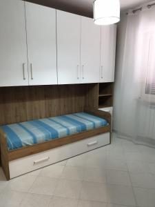 a bed in a room with white cabinets at Sperlonga ad un passo Casa Vacanza in Sperlonga