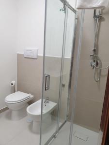 a bathroom with a toilet and a glass shower at Sperlonga ad un passo Casa Vacanza in Sperlonga +5 photos