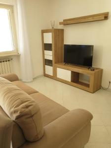 a living room with a couch and a flat screen tv at Sperlonga ad un passo Casa Vacanza in Sperlonga