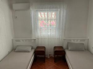 two twin beds in a room with a window at Apartment Dorada in Dobra Voda