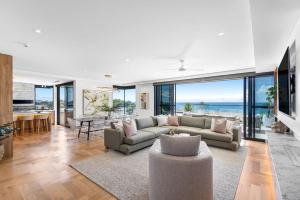 a living room with a couch and a table at Penthouse at First Bay Coolum in Coolum Beach