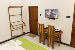a room with a table and chairs and a tv at Rayonaz Resort in Dambulla