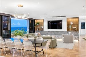 a living room with a table and chairs at Penthouse at First Bay Coolum in Coolum Beach