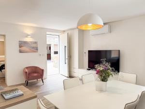 a dining room and living room with a white table and chairs at Gloria Holiday - Villa di Istria in Piran