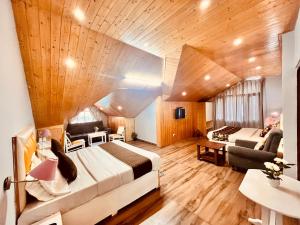 a hotel room with two beds and a couch at Hadimba Palace, Manali in Manāli