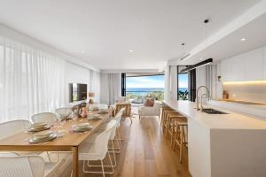 a kitchen and living room with a table and chairs at Coolum First Bay 121 in Coolum Beach