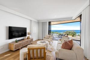 a living room with a couch and a tv at Coolum First Bay 121 in Coolum Beach