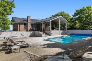 a backyard with a swimming pool and chairs and a house at 8535-Glesborg-Havstokken-12 in Glesborg