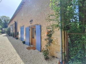 a building with blue doors on the side of it at The Lodge Gite 3 Star in Saint-Privat-des-Prés